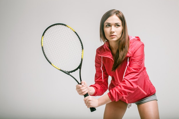 Giovane donna che tiene una racchetta da tennis