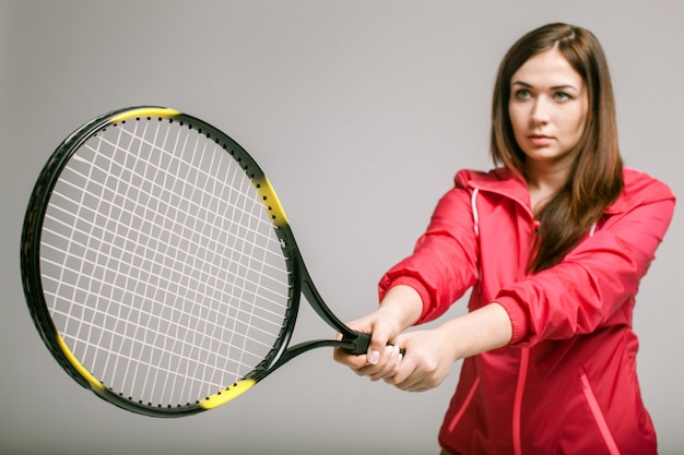 Giovane donna che tiene una racchetta da tennis