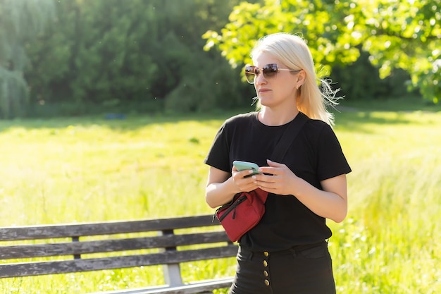 Giovane donna che usa lo smartphone al parco.