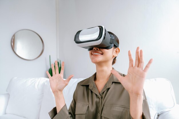 Giovane donna che usa occhiali di realtà virtuale a casa per un'esperienza estrema