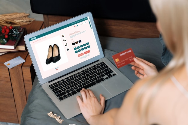 Giovane donna che usa un portatile con carta di credito per internet banking online shopping E-commerce con gateway di pagamento online a casa Moderno e comodo online shopping con carta di debito Blithe