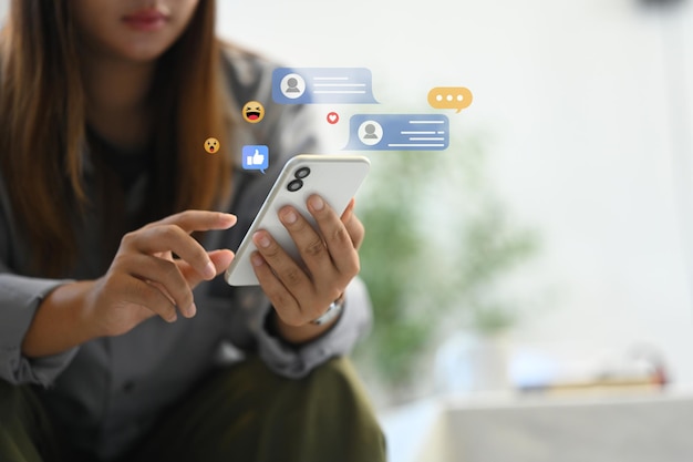 Giovane donna che usa uno smartphone con varie icone dei social media e bolle di chat