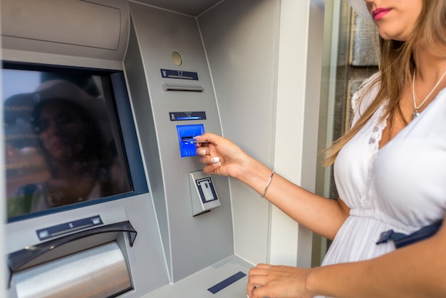 Giovane donna che utilizza ATM