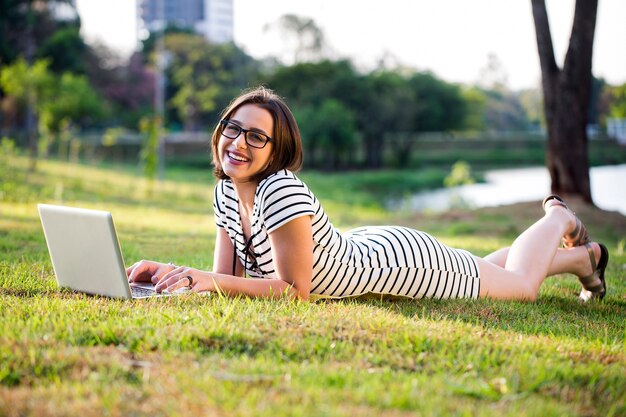 Giovane donna che utilizza computer portatile nel parco