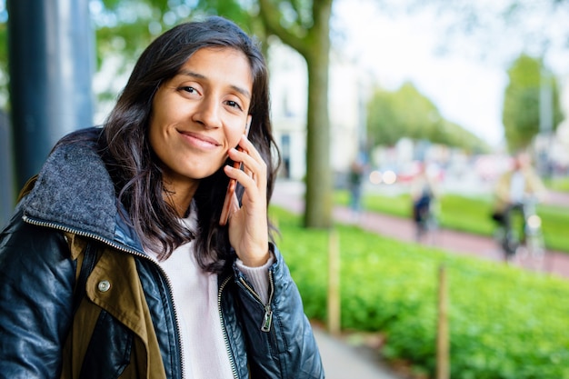 Giovane donna che utilizza il telefono cellulare nel parco