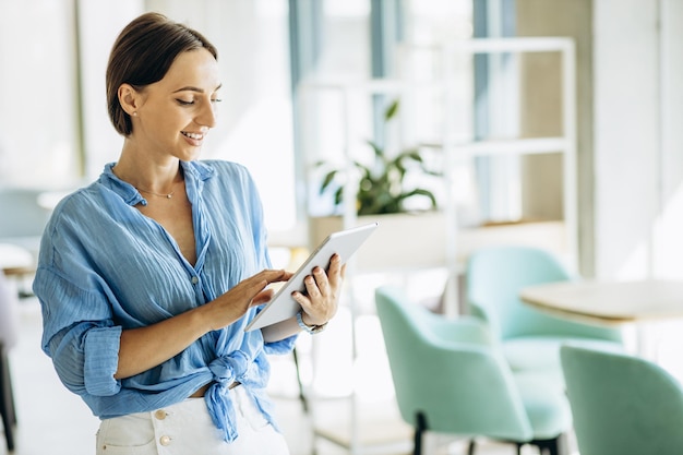 Giovane donna che utilizza tablet in un ufficio