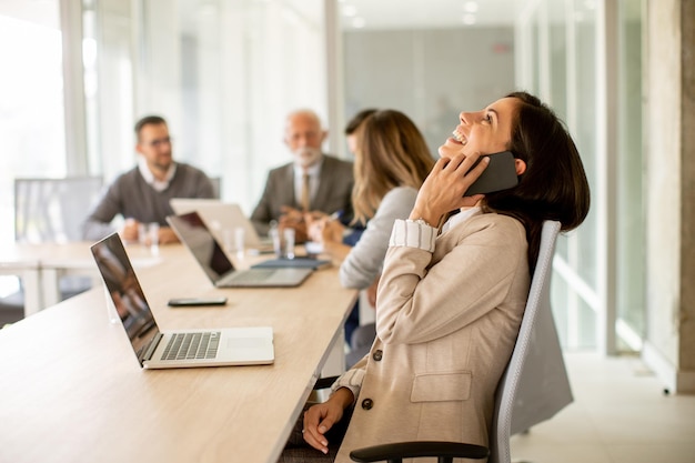 Giovane donna che utilizza telefono cellulare nell&#39;ufficio