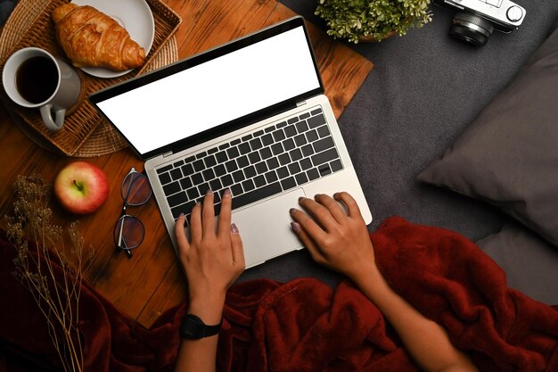 Giovane donna che utilizza un computer portatile sul tappeto grigio