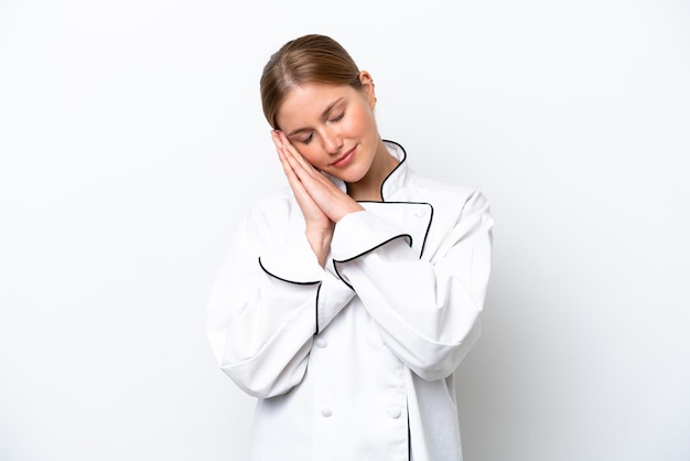 Giovane donna chef isolata su sfondo bianco che fa il gesto del sonno in un'espressione adorabile