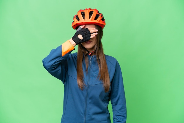 Giovane donna ciclista su sfondo chroma key isolato che copre gli occhi con le mani Non voglio vedere qualcosa