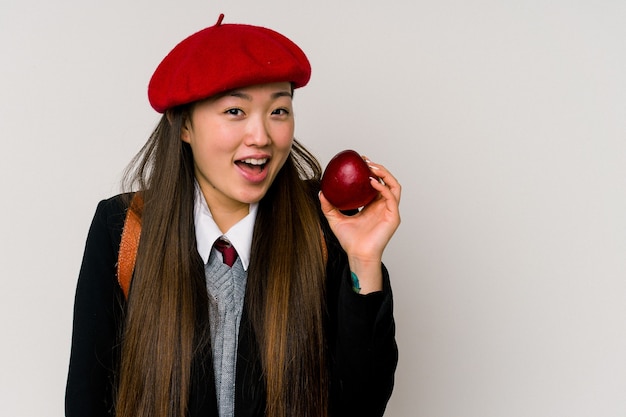Giovane donna cinese che indossa un'uniforme scolastica isolata sul muro bianco