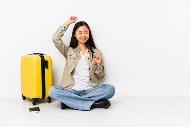 Giovane donna cinese del viaggiatore che si siede che tiene una carta d'imbarco che celebra un giorno speciale