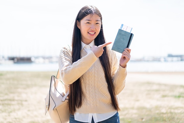 Giovane donna cinese in possesso di un passaporto all'aperto e indicandolo