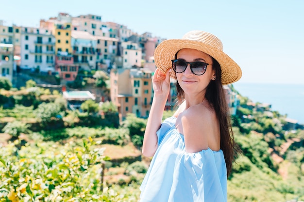 Giovane donna con bella vista al vecchio villaggio nelle Cinque Terre, Liguria, Italia.