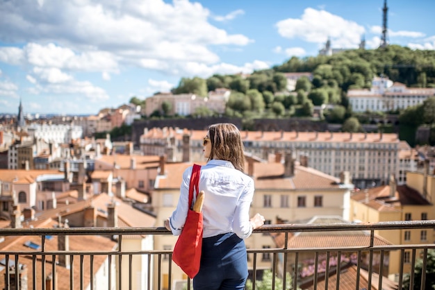 Giovane donna con borsa rossa che gode di una splendida vista sulla città di Lione in Francia