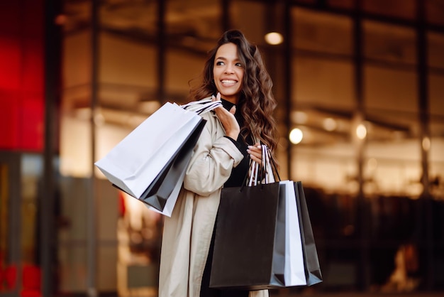 Giovane donna con borse della spesa vicino al centro commerciale Spring Style Il consumismo acquista lo stile di vita dello shopping