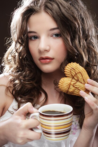 Giovane donna con caffè e biscotti