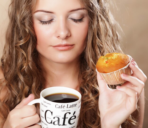 Giovane donna con caffè e muffin