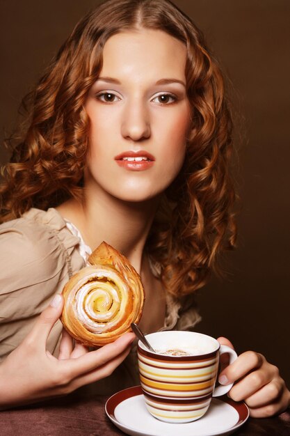 Giovane donna con caffè e torta