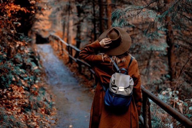 Giovane donna con cappello in un parco stagione autunnale