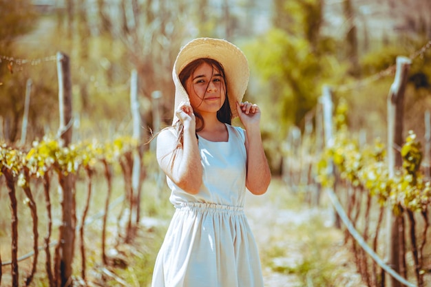 Giovane donna con cappello in un vigneto