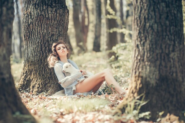 Giovane donna con capra nella foresta