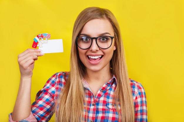 Giovane donna con carta e bandiere di diversi paesi di lingua.