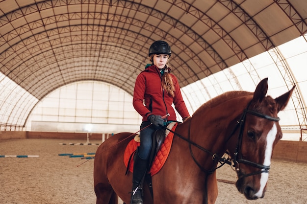 Giovane donna con casco a cavallo