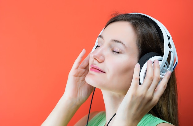 Giovane donna con cuffie musicali bianche.