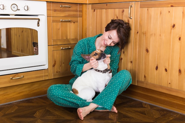 Giovane donna con cute cane jack russell terrier seduto sul pavimento