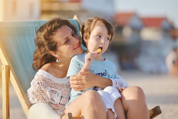 Giovane donna con fare da baby-sitter nella sedia sulla spiaggia di estate