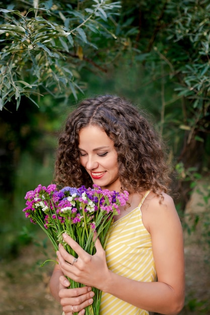 Giovane donna con fiori nelle mani