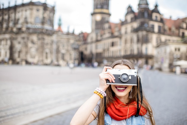 Giovane donna con fotocamera camminando sulla Theaterplatz a Dresda, Germany