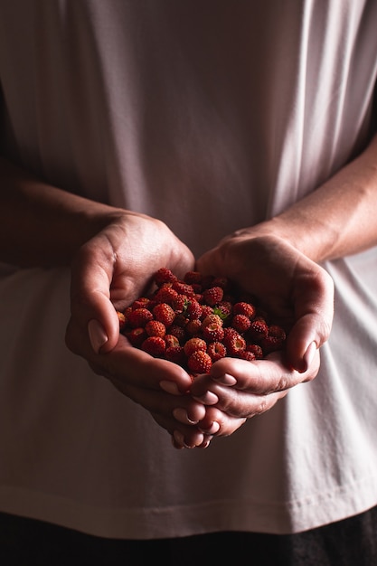 Giovane donna con fragole in mano