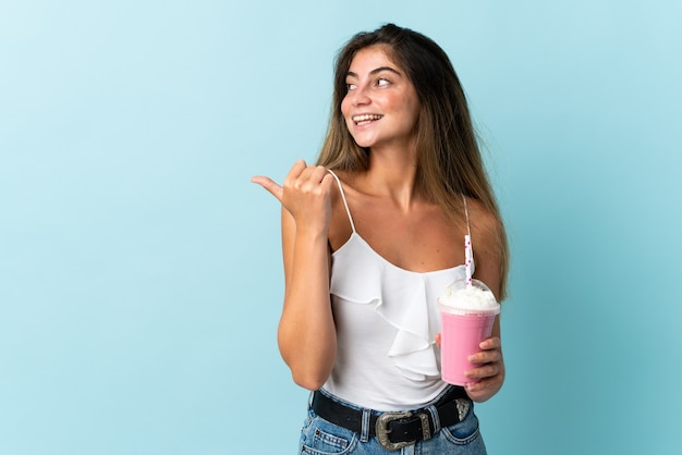 Giovane donna con frappè alla fragola isolato