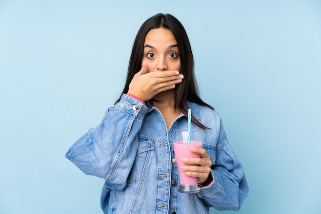 Giovane donna con frappè alla fragola isolato