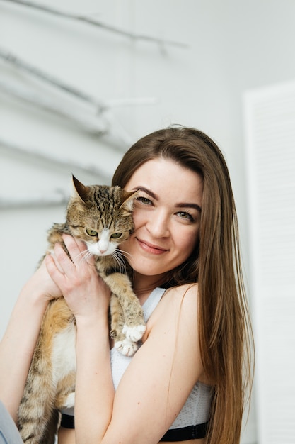 Giovane donna con gatto Ragazza in camera da letto leggera.