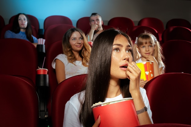 Giovane donna con gli amici a guardare film al cinema