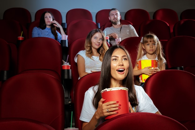 Giovane donna con gli amici a guardare film nel cinema