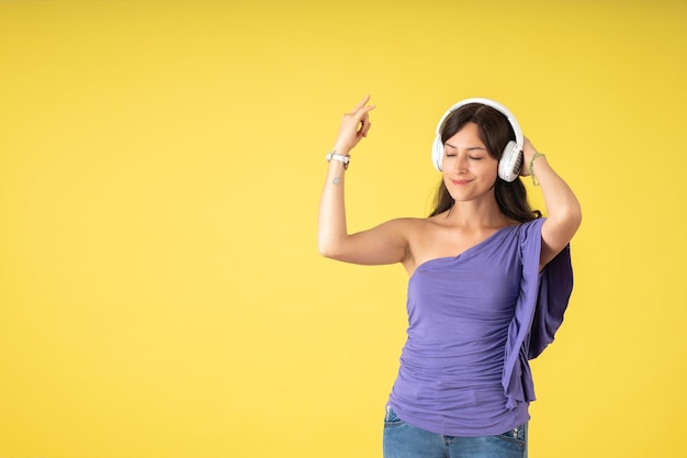 Giovane donna con gli occhi chiusi che balla al ritmo della musica