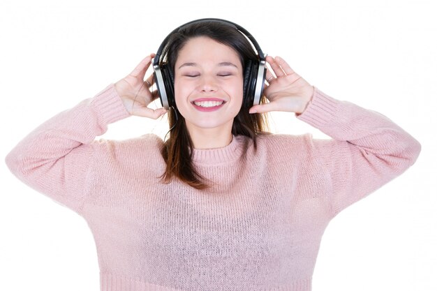 Giovane donna con gli occhi delle cuffie chiuso in maglione rosa