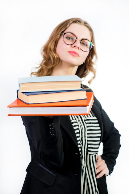 Giovane donna con gli occhiali in possesso di alcuni libri su bianco