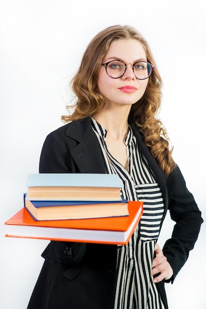 Giovane donna con gli occhiali in possesso di alcuni libri su bianco