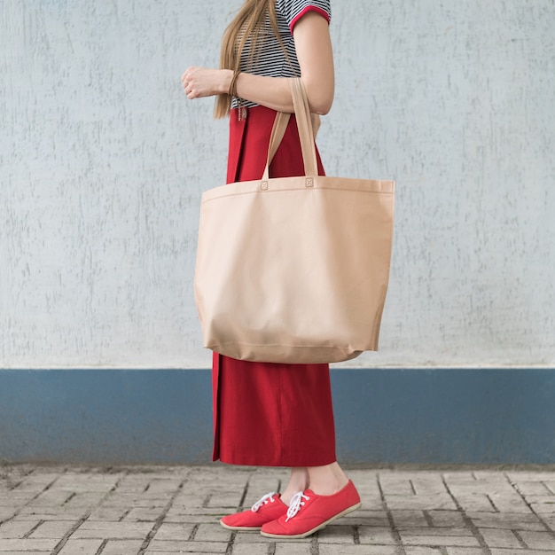 Giovane donna con grande borsa eco da shopper a portata di mano. Copia spazio