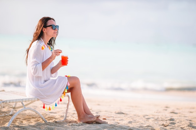 Giovane donna con gustoso cocktail in vacanza estiva