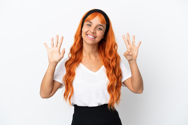 Giovane donna con i capelli arancioni isolati su sfondo bianco contando nove con le dita