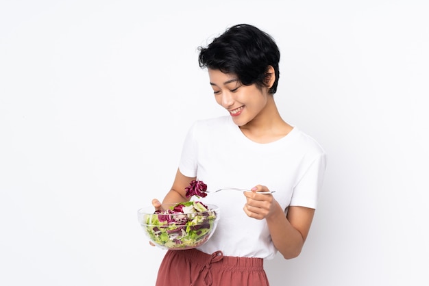 Giovane donna con i capelli corti che tiene un'insalata più