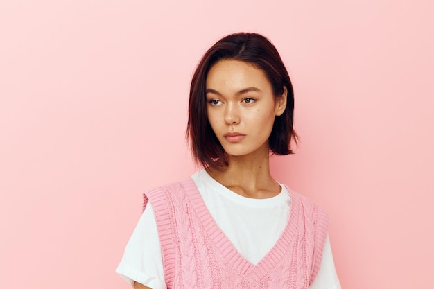 Giovane donna con i capelli corti e uno sfondo rosa maglione rosa