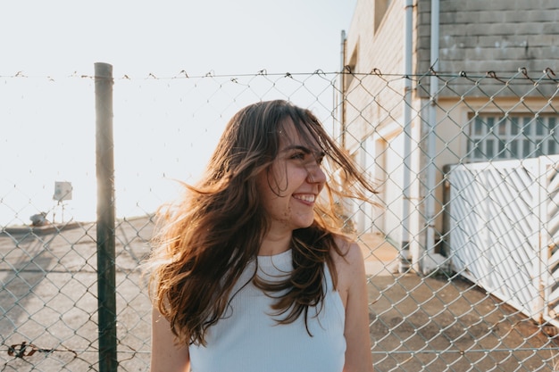 Giovane donna con i capelli lunghi muovendo i capelli durante un tramonto