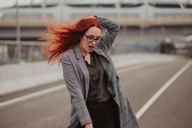 Giovane donna con i capelli rossi che ride con le parentesi graffe